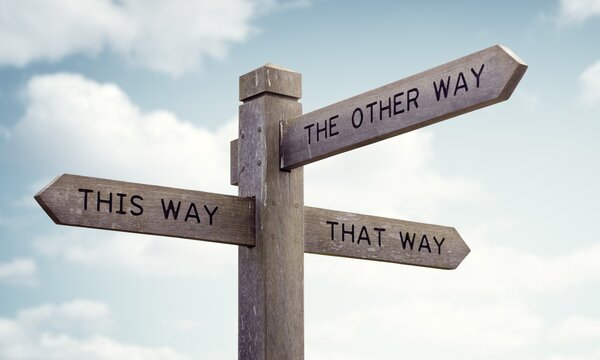 Ein Wegweiser, der in verschiedene Richtungen zeigt mit einem blauen Himmel als Hintergrund.