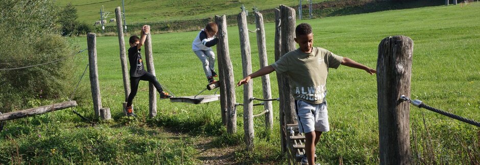 Kinder balancieren auf einem Spielplatz Holzgerüst auf dem Schulgelände.